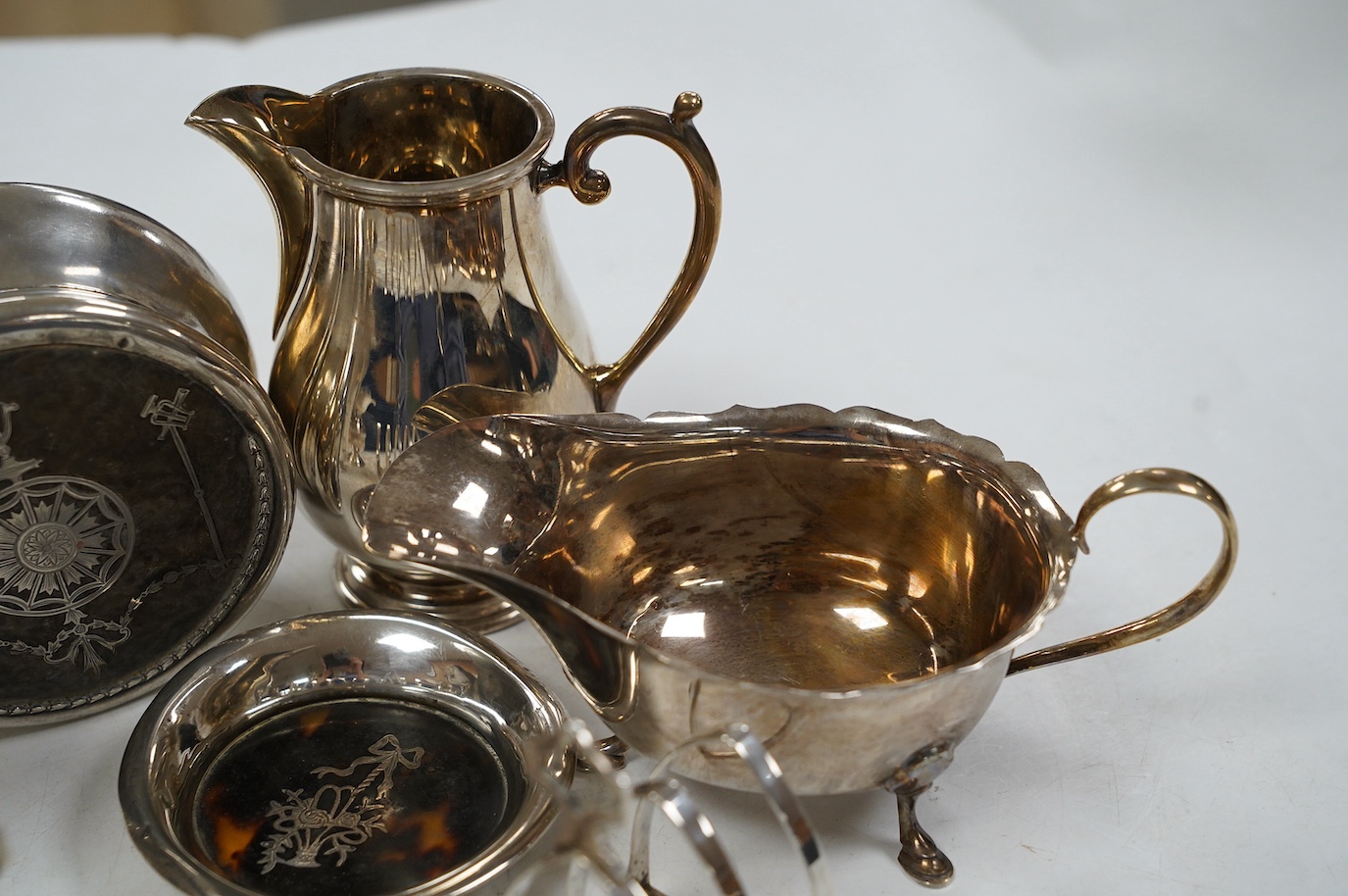 Sundry small silver including a pair of toast racks, Sheffield, 1936, three cream jugs, a sauceboat and two tortoiseshell mounted items. Condition - poor to fair to good